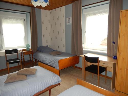 a bedroom with two beds and a desk and two windows at Gîte Cornimont, 3 pièces, 5 personnes - FR-1-589-70 in Cornimont