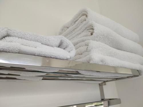 a pile of towels sitting on top of a shelf at Aarangi Tui Motel in Paihia