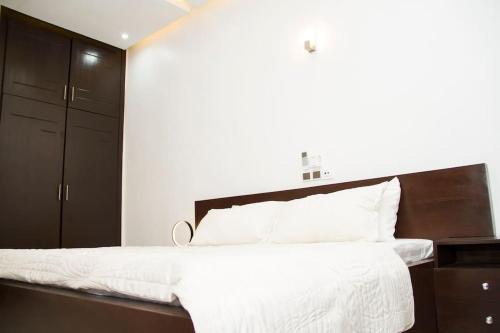 una camera da letto con un grande letto con lenzuola bianche di Luxueux Appartement meublé à Cotonou a Cotonou