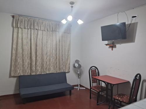 Il comprend un salon doté d'une télévision et d'une table avec des chaises. dans l'établissement Minidepartamento Barato, à Chiclayo