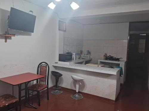 eine Küche mit einer Theke, einem Tisch und Stühlen in der Unterkunft Minidepartamento Barato in Chiclayo