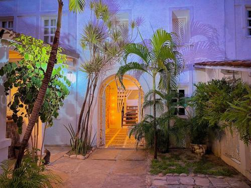 a hallway of a house with palm trees at Casarão Jeri in Jericoacoara