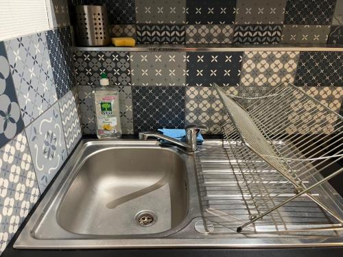 um lavatório de cozinha com um estendal ao lado em 010 CHIC & COSY F1 29m2 HYPERCENTRE WIFI SMART TV NETFLIX em Saint-Étienne