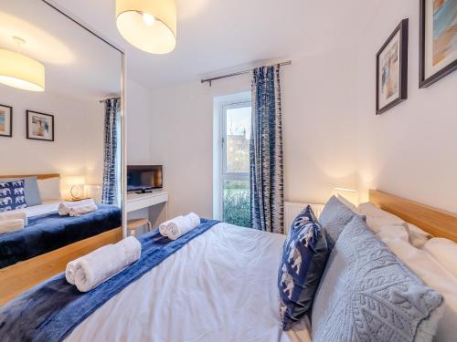 a bedroom with a large bed and a mirror at Whinstone House in Craster