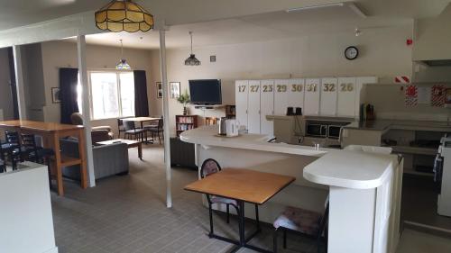a kitchen and living room with a counter and tables at Ruapehu Mountain Motel & Lodge in Ohakune