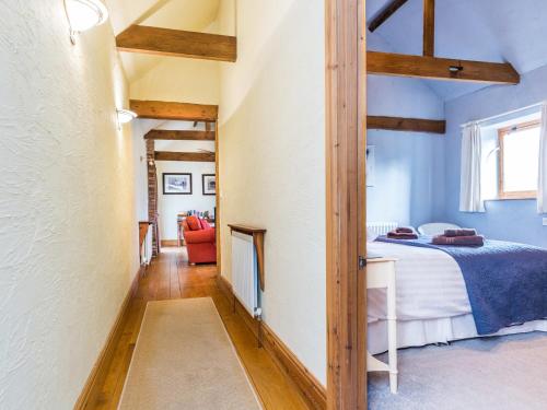 Schlafzimmer mit einem Bett in einem Zimmer mit Holzbalken in der Unterkunft Anvil Cottage in Biscathorpe