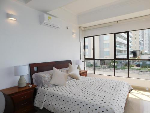 a bedroom with a bed and a large window at Apartamento Luxury frente al mar in Cartagena de Indias