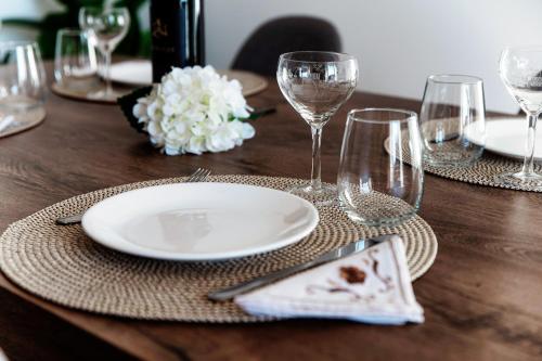 a wooden table with a plate and wine glasses at Lake & The City in Como