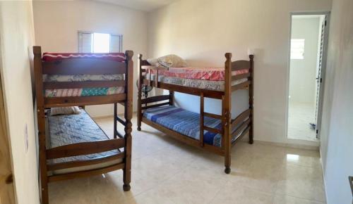 um quarto com 2 beliches num quarto em Casa temporada em peruibe em Peruíbe