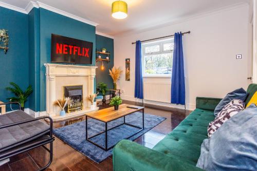 a living room with a green couch and a fireplace at Two Bed Entire House Newcastle Gateshead - Free Parking in Sheriff Hill