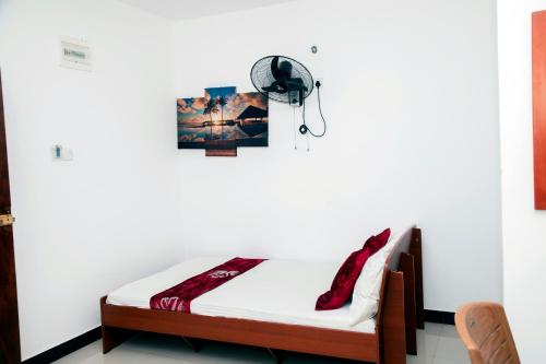 a bedroom with a bed with red shoes on it at Golden Star Guest House in Jaffna