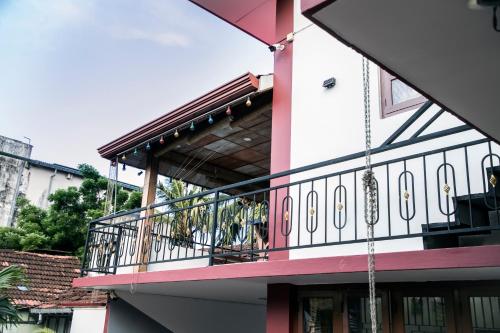 a balcony on a pink building with a chain at Golden Star Guest House in Jaffna