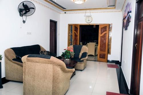 a living room with two chairs and a table at Golden Star Guest House in Jaffna