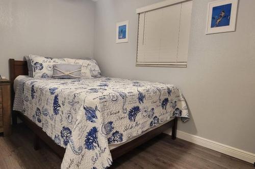 a bedroom with a bed with a blue and white blanket at The Salty Cove IRB in Clearwater Beach