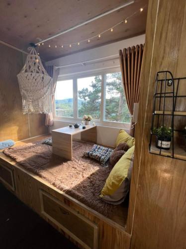 a room with a bed with a desk and a window at Belle House Đà Lạt in Da Lat