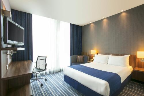 Cette chambre comprend un lit et une télévision à écran plat. dans l'établissement Holiday Inn Express Utrecht - Papendorp, an IHG Hotel, à Utrecht
