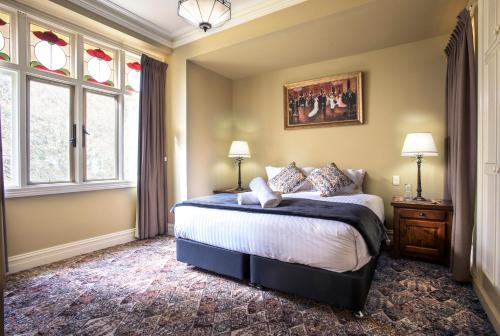 a bedroom with a bed and two windows at Sassafras village stay - historic home sleeps 4 in Sassafras