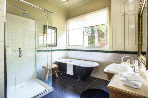 a bathroom with a tub and a sink and a shower at Sassafras village stay - historic home sleeps 4 in Sassafras