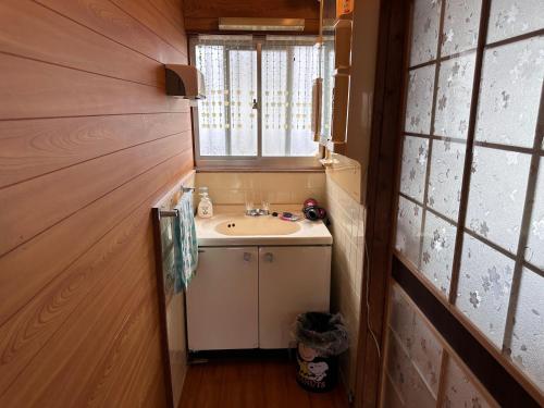a small bathroom with a sink and a window at Guest House Island in Wakamatsu