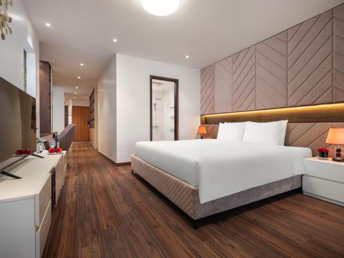 a bedroom with a large white bed and a desk at MoonLight Tay Ho in Hanoi