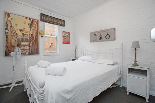 una camera bianca con un grande letto bianco e una finestra di Bluebird Cottage a West Tamworth