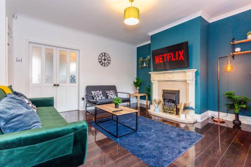 a living room with a green couch and a fireplace at Two Bed Entire House Newcastle Gateshead - Free Parking in Sheriff Hill