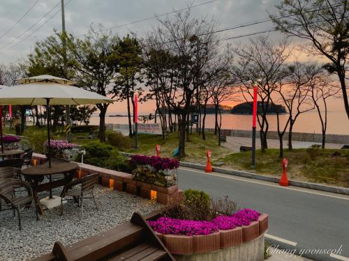 a park with a table and benches and flowers at Hotel Terramar in Boryeong