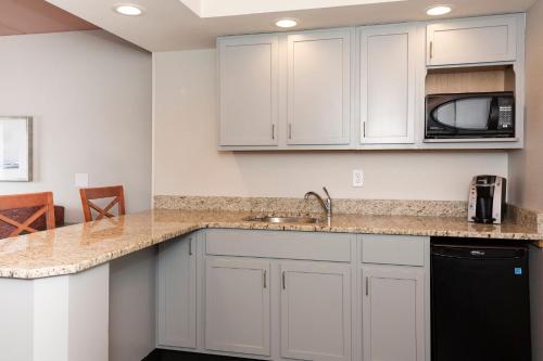 a kitchen with white cabinets and a sink at Holiday Inn Marquette by IHG in Marquette