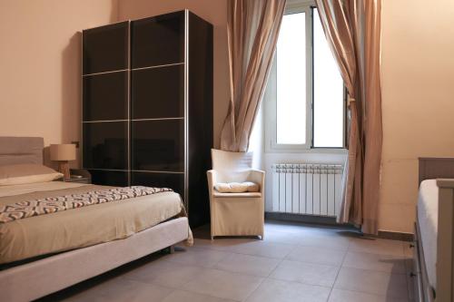 um quarto com uma cama, uma cadeira e uma janela em Domus Superior Banchi Nuovi - Navona Pl. - Pantheon em Roma