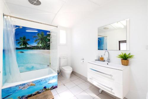 baño blanco con bañera y lavamanos en Silver Sands, 29 Victoria Pde water views and across the road to the water, en Nelson Bay