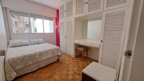 Habitación pequeña con cama y ventana en DepArt en Rambla Punta Carretas, en Montevideo