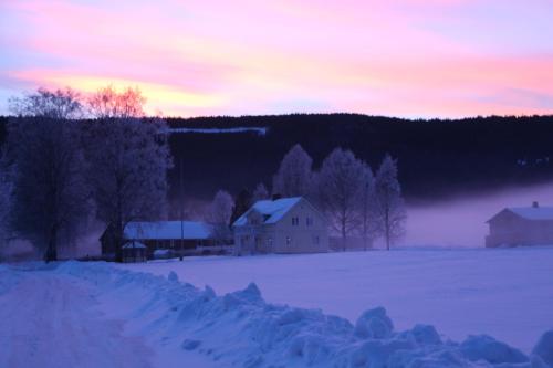 a house in a snowy field at sunset at Björkebo Camping in Stöllet