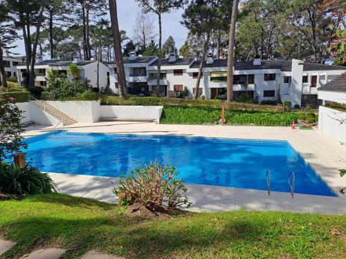 una piscina en un patio con casas al fondo en Villaggio Riviera, en Punta del Este