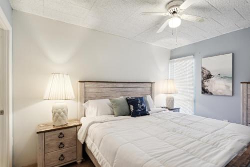 une chambre avec un grand lit et un ventilateur de plafond dans l'établissement Fun & Comfy Beachside Getaway ~ King Bed ~ Balcony, à Ocean City