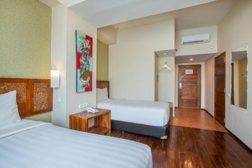 a hotel room with two beds and a table at 1O1 URBAN Jakarta Thamrin in Jakarta