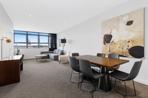 uma sala de estar com uma mesa e cadeiras e um sofá em Premium Apartments Chatswood em Sidney