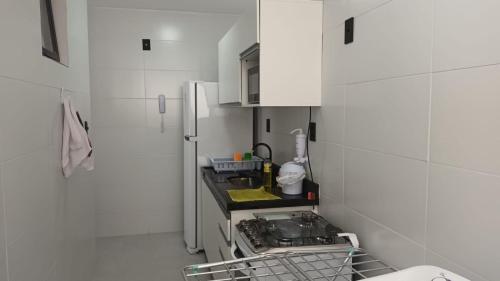  La cuisine est équipée de placards blancs et d'un réfrigérateur. dans l'établissement Apartamento novo no Bessa, à João Pessoa