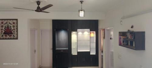 a room with a black cabinet and a ceiling fan at Sharma's Exquisite 2 BHK HomeStay in City of Taj in Agra