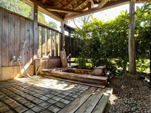 a wooden porch with a bench on a deck at まんのう清流庵 in Manno