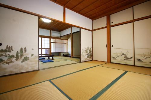 an empty room with paintings on the walls at まんのう清流庵 in Manno