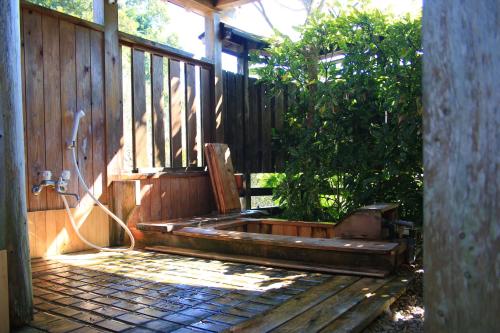 a wooden porch with a bench on a deck at まんのう清流庵 in Manno