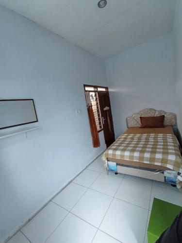 a bedroom with a bed in a white room at Villa Lilly in Batu