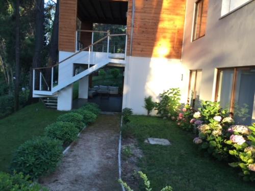 ein Haus mit einer Treppe und einem Garten mit Blumen in der Unterkunft House & Lake rapel in Las Cabras