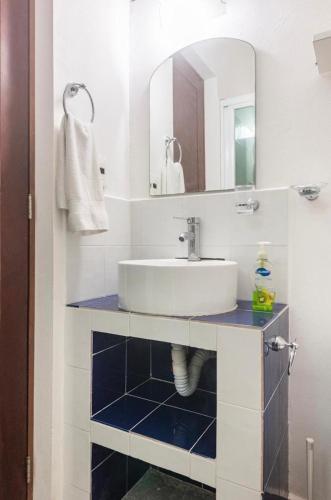 a white bathroom with a sink and a mirror at Private Room Puerto Morelos in Puerto Morelos