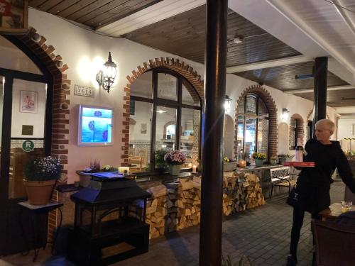 a woman standing in a restaurant with a table at Penzion Verde Rosa in Harrachov