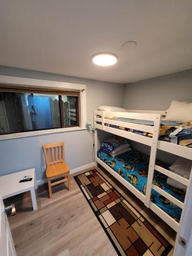 a bedroom with two bunk beds and a chair at The Dune Beach House in Norfolk