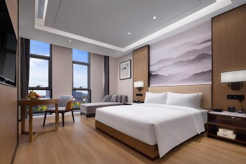 1 dormitorio con 1 cama blanca grande y escritorio en Metropark Hotel Wuhan, en Wuhan