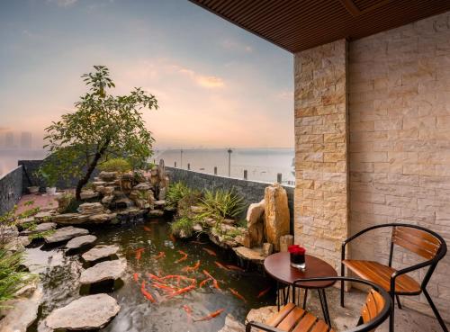 a koi pond in a patio with a table and chairs at MoonLight Tay Ho in Hanoi
