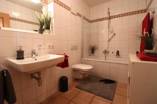 Un baño con lavabo, inodoro y bañera. en Oewern Diek App 06, en Wustrow