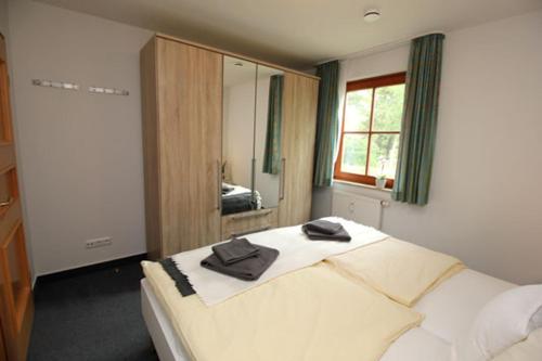 Un dormitorio con una cama con toallas. en Oewern Diek App 03, en Wustrow